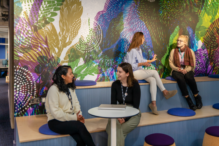four people talking in a shared meeting space