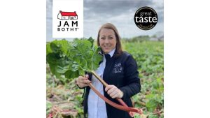 Woman holding rhubarb stalks next to the Jam Bothy logo