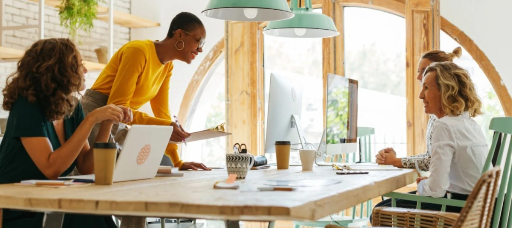 Catalina Banuleasa at a table with three co-workers.
