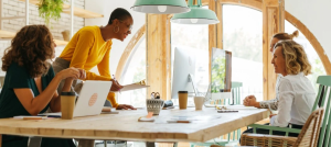 Catalina Banuleasa at a table with three co-workers.