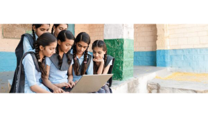 A group of young students gathered around a laptop