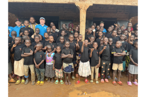 A large group of children standing together with a few adults