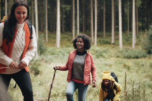 Woman and girls walking through forest