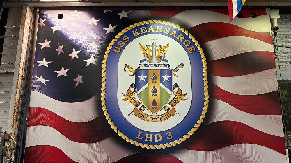 American flag with emblem for USS Kearsarge on top
