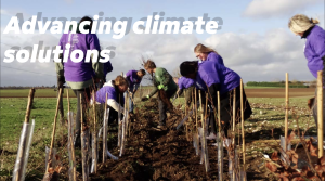 "Advancing climate solutions" with picture of people planting together